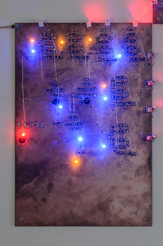 A plate of copper with shining blue, yellow and red LEDs on it. There are structures made of transistors engraved into the surface.