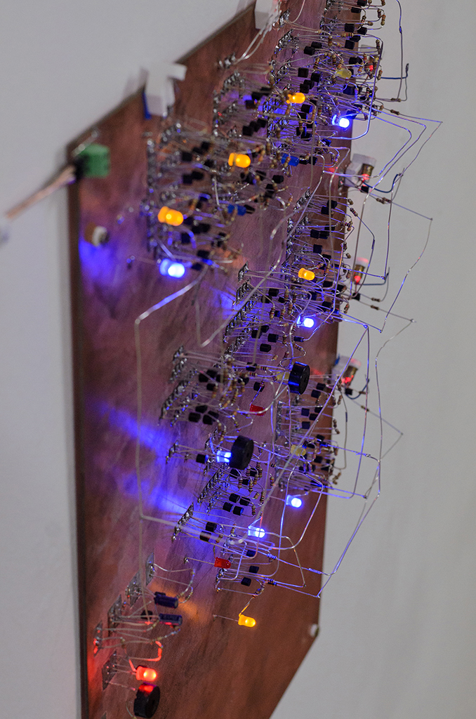 A plate of copper shown in detail. Hundreds of small components are mounted to its surface, they themselfes connected with silver wire.