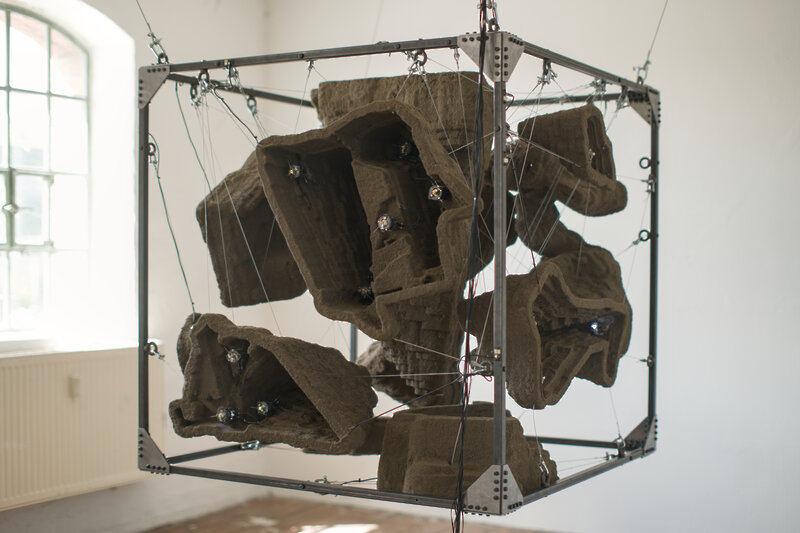 A detail shot of the frame. The structures are fixed with steel cables. The frame resembles an industrial structure.