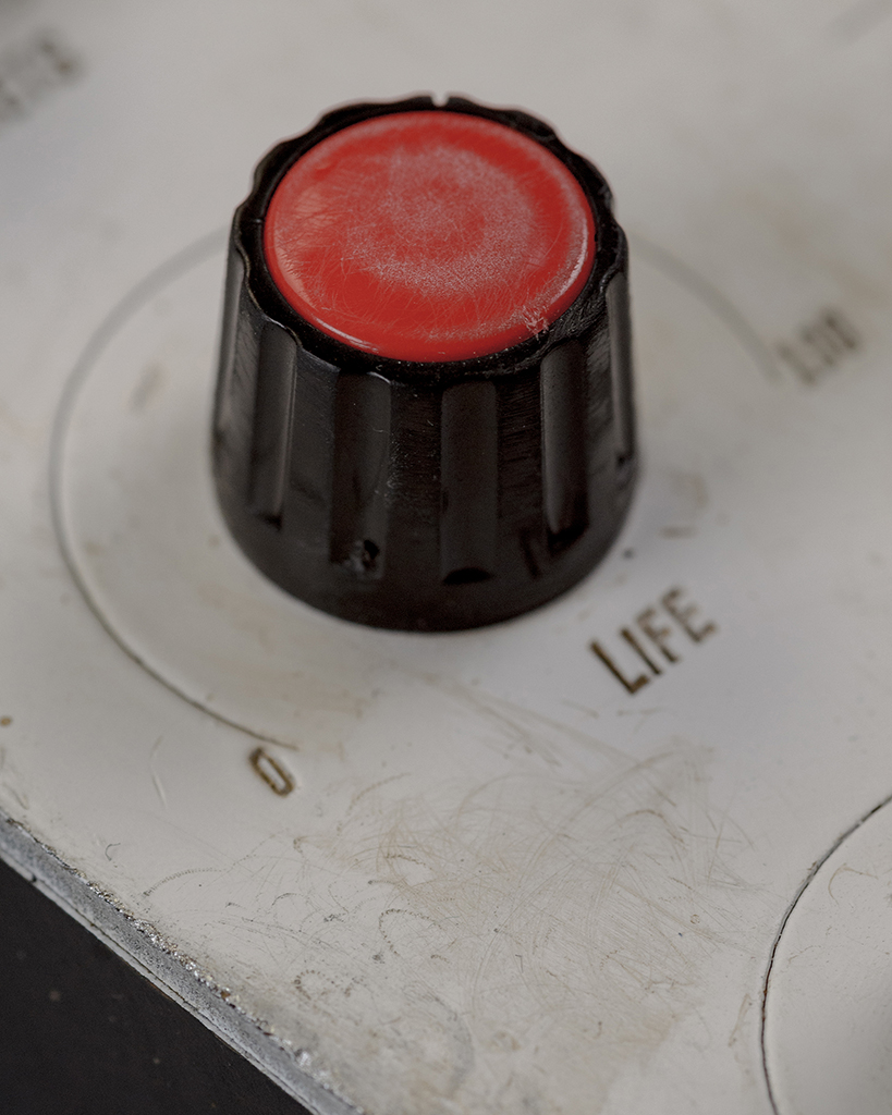 A knob in detail. It looks worn and weathered, as does the white surface.